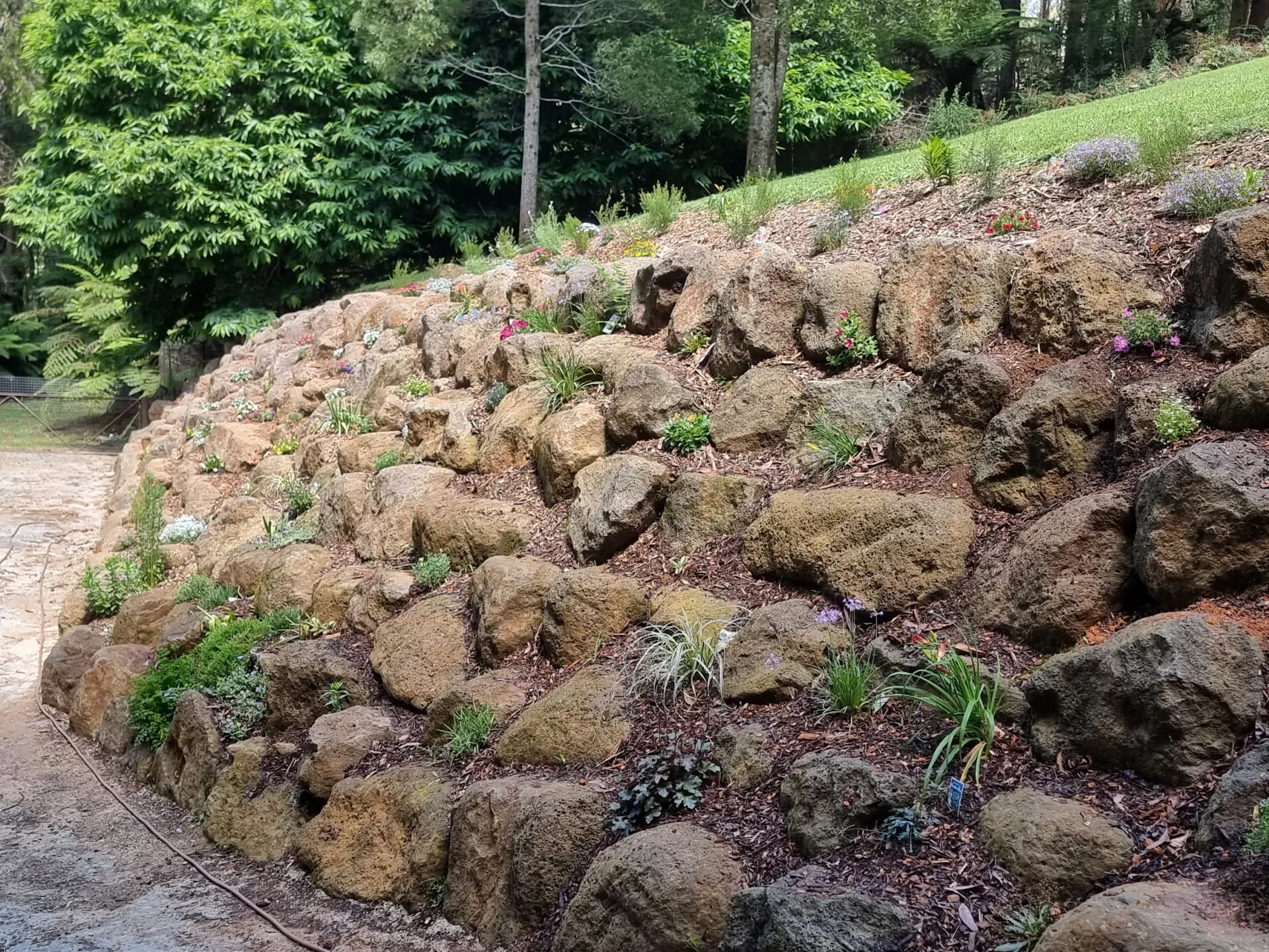 Massive rock wall, surfaced road and corten steel work area completed by Rock'n Earthworks in Olinda