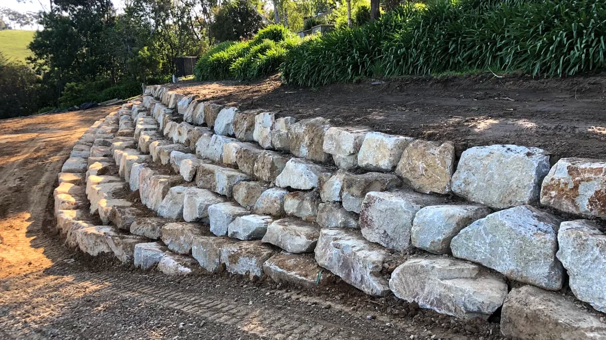 Curved rock retaining wall built into a hillside garden