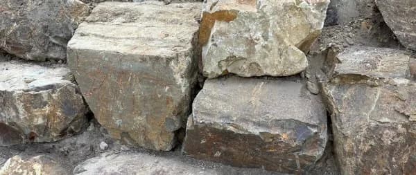 Close-up of large Coldstream stone blocks with rust and grey tones locked into a wall face