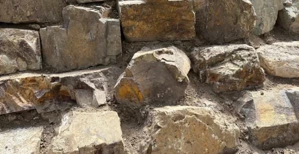 Coldstream stone wall detail with a rounded feature rock, brown and gold running through the face