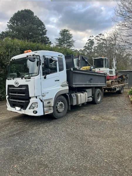 UD Quon tipper hooked up to a plant trailer carrying the Takeuchi excavator
